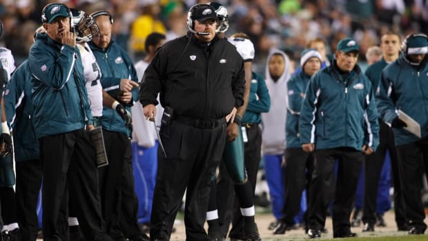 Philadelphia Eagles head coach Andy Reid along the sidelines surrounded by Eages personnel